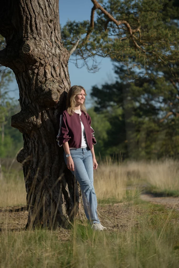 Jasmijn Bosman lachend bij een boom op de heide